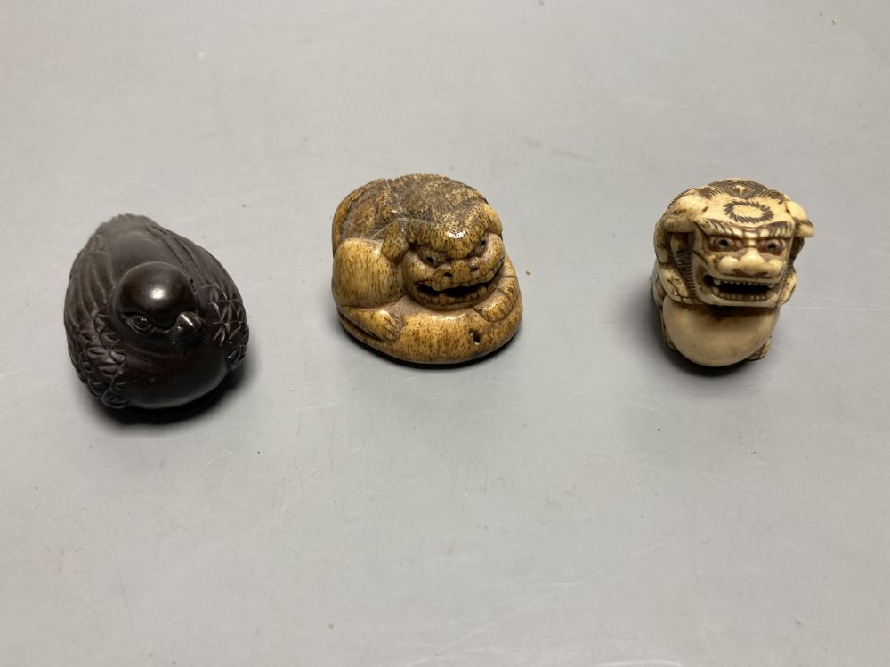 Two Japanese staghorn netsuke of lion dogs, two ivory netsuke of a lotus pod and a manju, 19th century and two modern wood netsuke